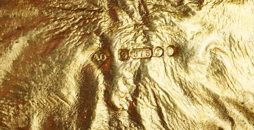 Dunhill, an attractive 9ct gold and sapphire snuffbox, circa 1973, the rectangular box of samorodok finish, the hinged lid set with a foil-backed oval sapphire, measuring approximately 5.1 x 2.7 x 1.6cm, signed Dunhill L